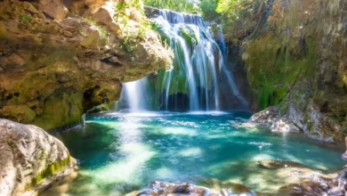 Stunning waterfalls cascade through a gorge, showcasing breathtaking natural beauty in a serene landscape. Chefchaouen & Akchour Waterfalls Day Trip from Fes